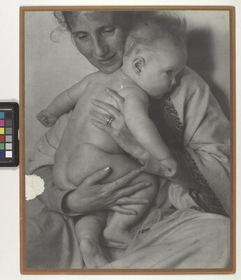A black-and-white photograph of a White woman holding a naked baby to her chest.