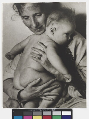 A black-and-white photograph of a White woman holding a naked baby to her chest.