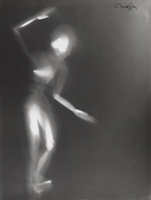A black-and-white photograph of a white person-shaped puppet dancing on a black background.