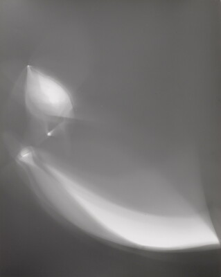 An abstract black-and-white photograph of foggy, white shapes against a black background.