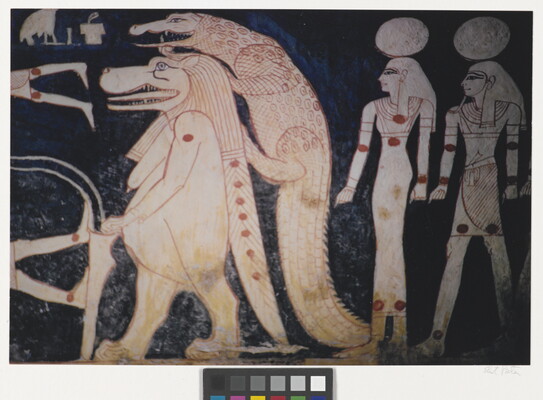 A color photograph of a mural with white and red hieroglyphs featuring what looks like a lion walking upright, a crocodile climbing on its back, and two people with circles over their heads.