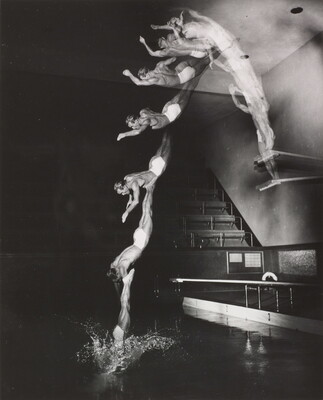 A black-and-white photograph of a White man diving into a pool from a high board; multiple blurred images show the man in motion.