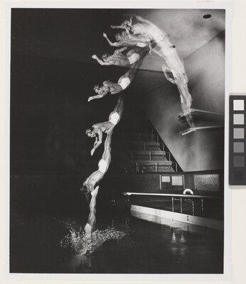 A black-and-white photograph of a White man diving into a pool from a high board; multiple blurred images show the man in motion.