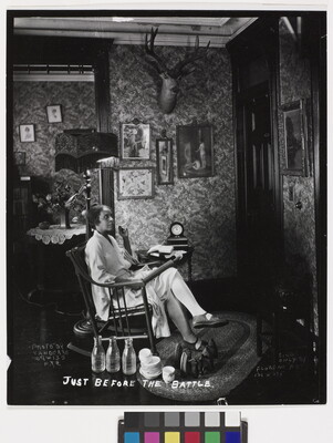 A black-and-white photograph of a Black woman in a rocking chair, holding a rolling pin on her lap, waiting at a front door.