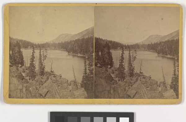 Two almost identical sepia-toned photographs side by side of a lake and rocky mountain landscape.