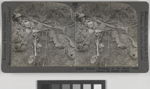 Two almost identical side-by-side black-and-white photographs of a human skeleton laying in the dirt amongst remnants of clothing and weapons.