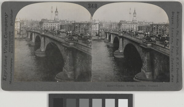 Two almost identical black-and-white photographs side by side of a brick arch bridge that spans a river, pedestrians and cars on top, and a city skyline in the background.