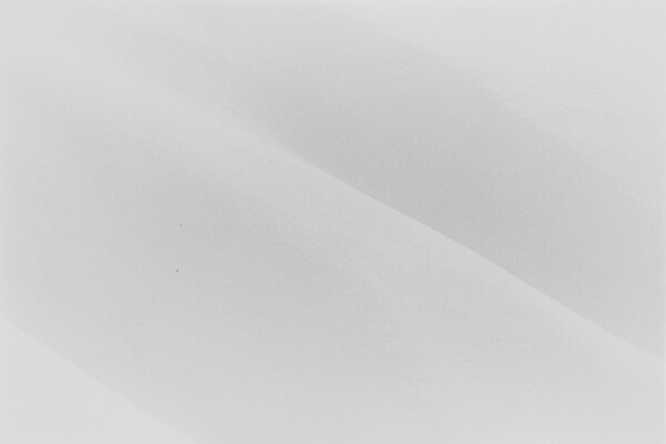 A black-and-white landscape photograph of snow covered hills.