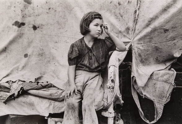 A black-and-white photograph of a young White girl wearing dirty clothes, one hand held up to her forehead, sitting in front of a canvas tent.