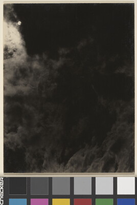 A black-and-white photograph of a dark, cloudy sky with the sun or moon shining through clouds.