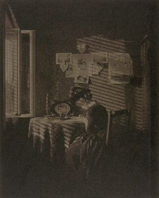 A sepia-toned photograph of a seated woman writing at a table, illuminated by light from a window.