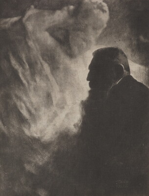 A soft-focus, black-and-white photograph of an older man with a big beard in profile against a light gray, almost smokey, background.