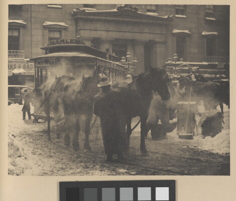 A black-and-white photograph of horses pulling a trolley on a busy street covered with slush and snow.