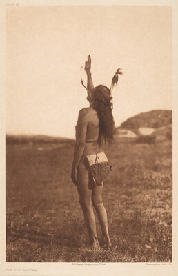 A sepia-toned photograph of an Indigenous person from the back, one arm raised, a feather in their long hair, wearing what looks like a beaded breechcloth.