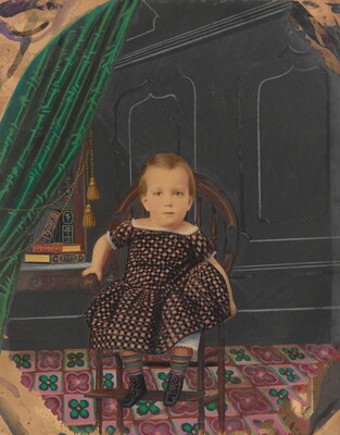 A color photograph of a White child wearing a plaid dress seated on a chair in a wood-paneled room with green curtains.