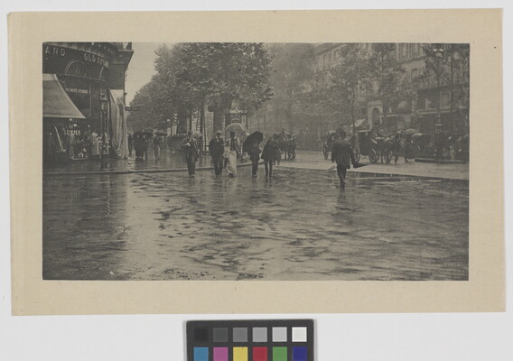 A black-and-white photograph of people crossing a city street in the rain.