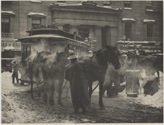 A black-and-white photograph of horses pulling a trolley on a busy street covered with slush and snow.