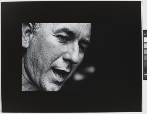 A black-and-white close-up photograph of the face of a White man who appears to be speaking.