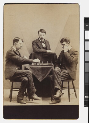 A sepia-toned photograph of the same White man with a moustache wearing a suit seated in three different positions around a chess board.