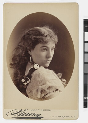 A sepia-toned studio portrait photograph, framed in an oval, of a young White woman gazing over her shoulder.
