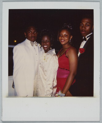 A color Polaroid photograph of two young Black couples in formal dress, one couple dressed in white the other in red and black, posing together.