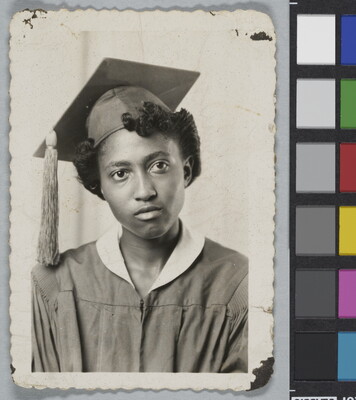 A black-and-white studio photograph of the head and shoulders of a Black woman in a graduation cap and gown.