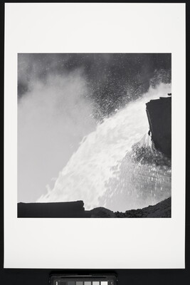A black-and-white photograph of a close up of molten metal being poured.