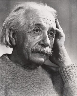 A black-and-white photograph of an older White man with white hair and mustache holding one hand up to the side of his face.