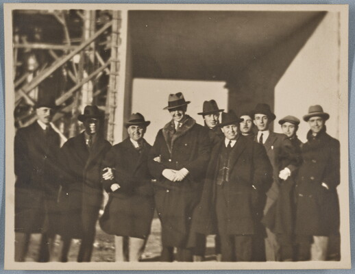 A black-and-white photograph of a group of White men, most wearing hats and overcoats, outdoors.