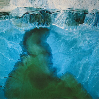 A color photograph of a blue, green, and white rock formation.
