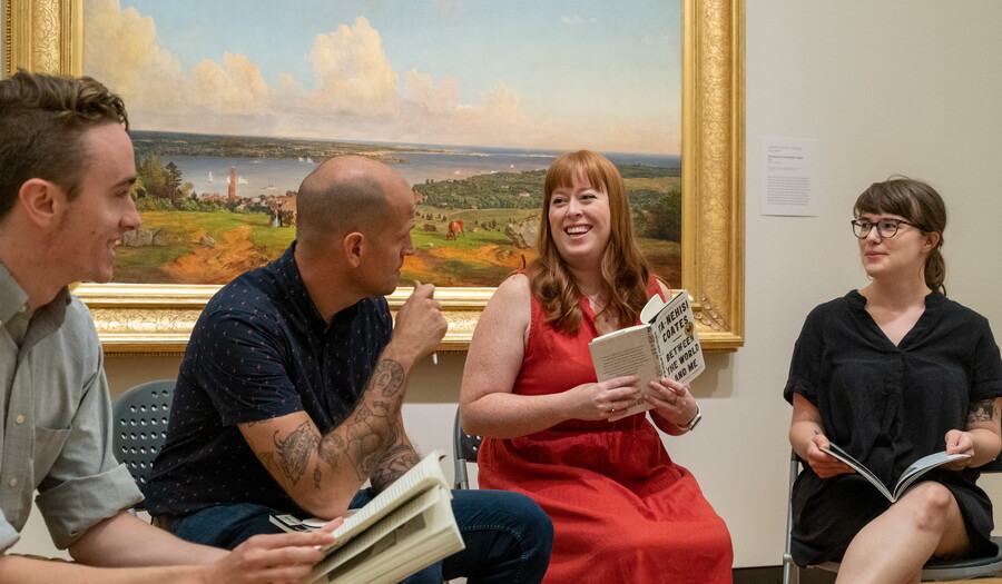 A group of people reading a book in one of the Carter's galleries.