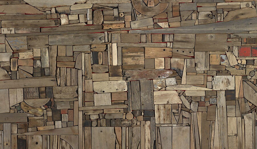 A detail of a flat abstract assemblage of wood pieces in various shapes, sizes, and colors fitted together perfectly like puzzle pieces.