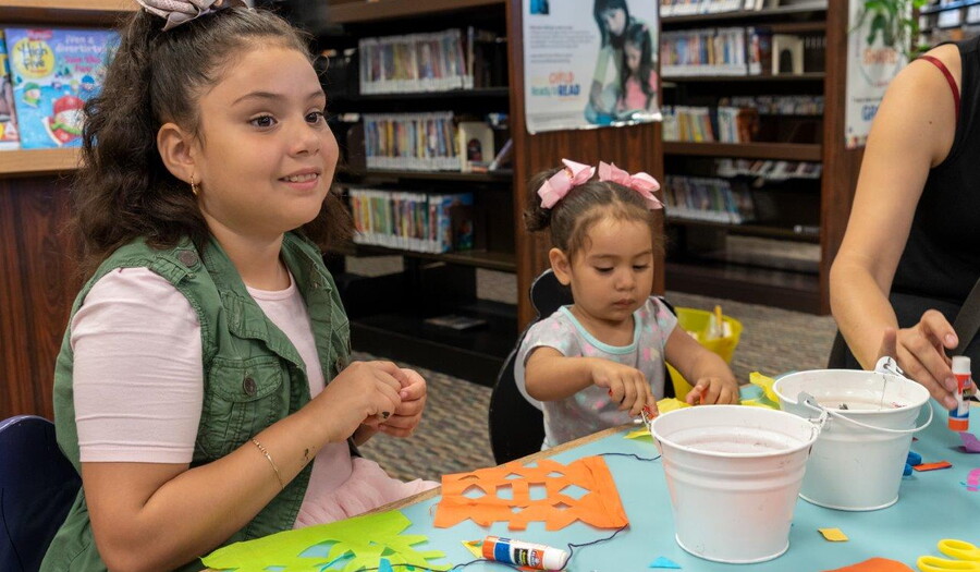 Children make art at a table.