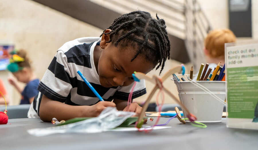 A child works on an art project at a table.