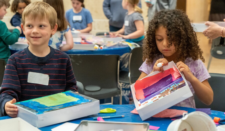 Two children at a table in the Carter Atrium make art.