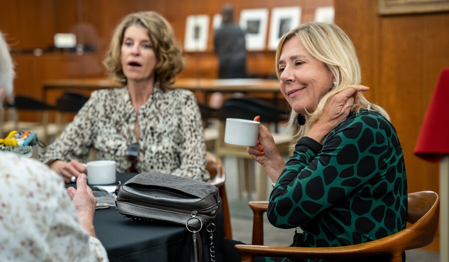 Two adults drink tea and talk.