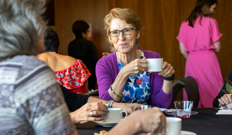 A group of people drink tea at tables in the Carter&#039;s Lounge.