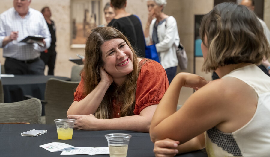 Two White women are enjoying conversation at a table in the Carter&#039;s Atrium.
