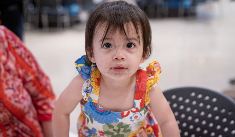 A close-up of a young child on an adult's lap in the Carter's Atrium.