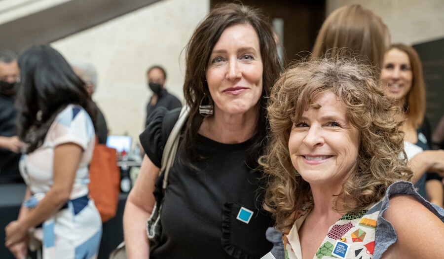 Two smiling White women pose next to each other in the Carter's Atrium.