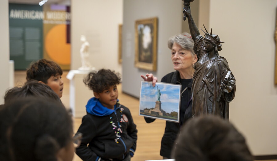 A Carter educator discusses a sculpture with students in a Carter gallery.