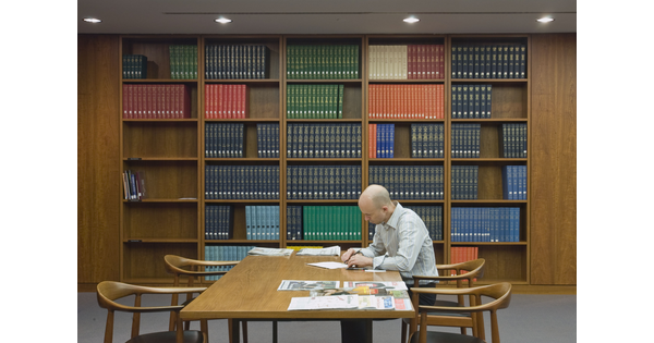 The interior of the Carter&#039;s library. Shelves with research volumes are along the wall in the rear of the image, and in the foreground a single researcher is seated at a table reviewing material.