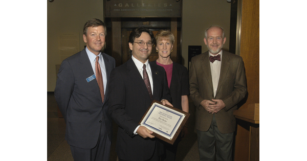 Recipient of the Innovative Teaching Award surrounded by three people.