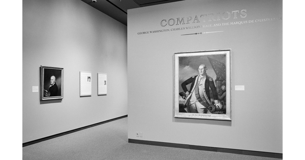 Black-and-white photo showing exhibition title wall featuring a painting of George Washington; a wall leading into the gallery features another portrait.