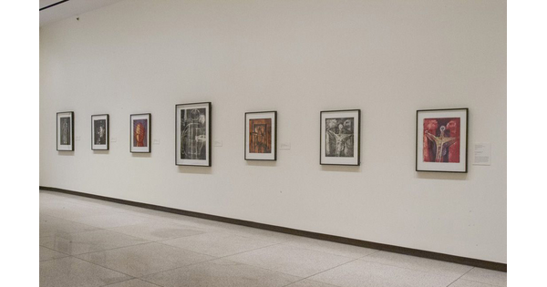 White gallery wall; seven framed prints hang on the wall.