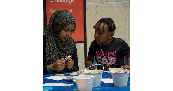 An adult and child work on an art project together.