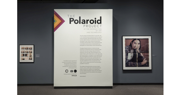 Exhibition title wall featuring introductory text on a white panel. To the right is a framed photo collage portrait of a man; to the left is a framed contact sheet.