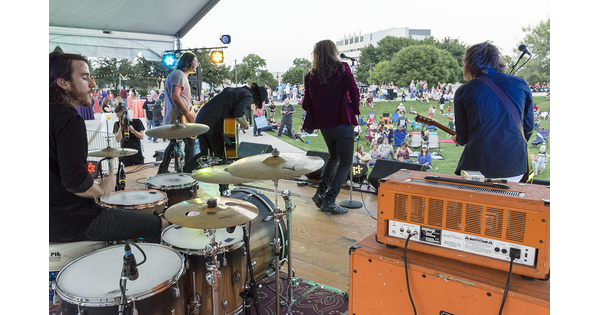 View from behind of a band performing for people gathered on the Carter&#039;s grassy lawn.