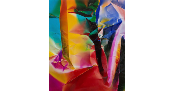 An abstract color photograph of what looks like crumpled paper in blue, pink, yellow, green, and red.