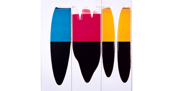 A color photograph of four vertically-oriented abstract stapes, the bottom half of each is black, and the tops are blue, red, and yellow.